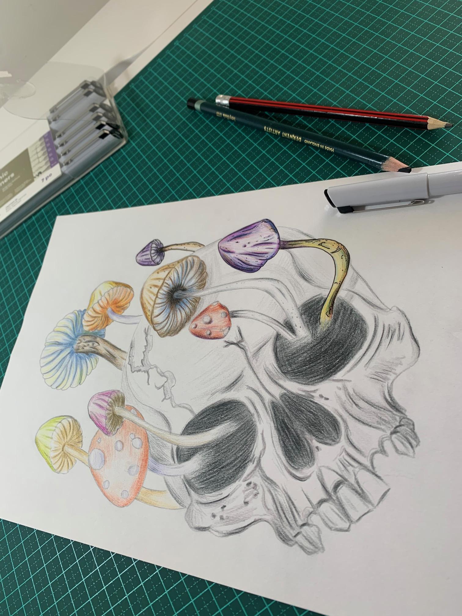 Overhead view of the studio desk — skull and mushroom illustration mid-progress